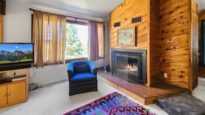 After a day of adventures curl up by the fireplace while you enjoy the view out the large windows overlooking the trees.
