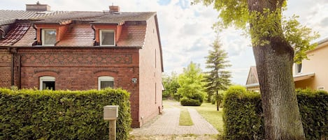 Amidst an enchanting village setting, you'll find the charm of this old brick country house. The spacious property is situated on a tranquil street, allowing you to conveniently park your vehicle right on the premises.