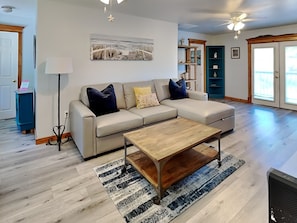 The living area with a sleeper sofa and porch access