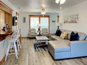 The living area with a sleeper sofa and porch access