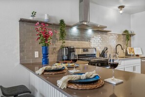 The spacious kitchen has an island with seating for 4, stainless appliances, and is fully stocked.