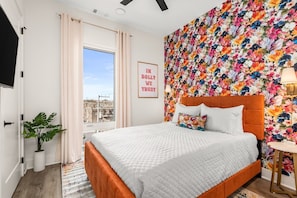 Get wrapped up in this funky floral queen suite with cool gel mattress, smart TV, ceiling fan, charging station, 4 drawer chest in closet, and wall sconces  for ambient lighting