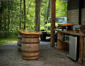 Outdoor kitchen with flat top griddle, bbq grill, toaster oven & mini fridge. 