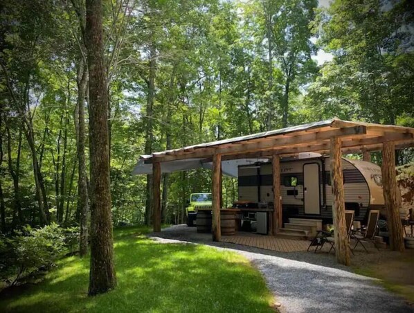 Camper, covered outdoor kitchen and sitting area. 