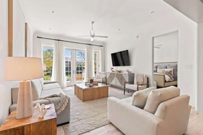 Light-filled living room with French doors opening right onto the private patio and terrace and right onto 30A
The living room features a king size sleeper sofa, plenty of seating, and a 65" Smart TV