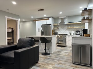 Large gathering area and kitchen with stainless appliances.
