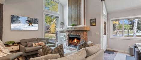 Cozy living area with gas fireplace, large picture windows and space to relax