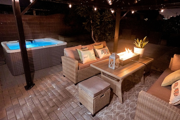 Private cozy patio with hot tub, fire pit, and decorative lights