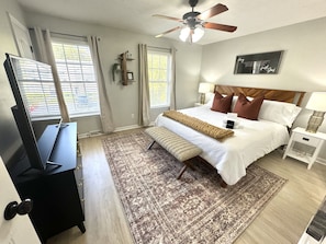 Cozy Comfort and Restful Nights: Unwind in our Inviting Primary Bedroom with a king size bed, and Embrace Serenity with Darkening Curtains for a Peaceful Sleep Experience.