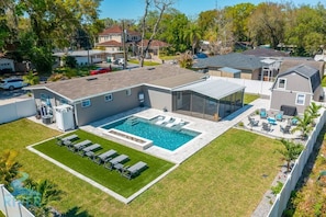 Surprisingly spacious private backyard with beautifully landscaped perimeter fence. Enjoy four distinct outdoor areas: heated pool and lounging area, a small group seating area, open lawn area, and screened lanai. Plenty to do for family and friends.