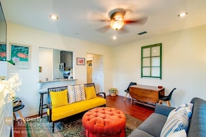 Bright colours, light, plush furnishings, and a kitchen where you can eat and chat make this living area beautiful.