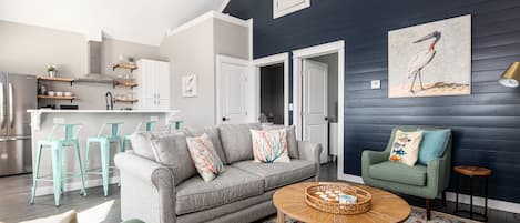 Living space with queen sofa, two arm chairs, games, beach towels, ceiling fans