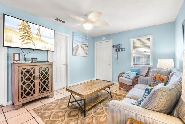 Living area is tastefully decorated and features a large wall-mounted TV