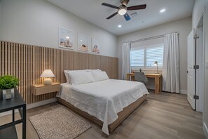 Spacious bedroom featuring a luxurious king bed, a dedicated workspace with a desk and chair, and stunning views of the Catalina Mountains. Ideal for both relaxation and productivity! Enjoy the perfect blend of comfort and convenience during your stay!