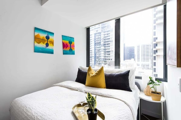 A double bed with plush pillows & city views.