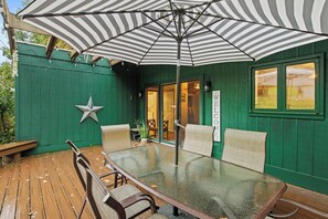 An inviting outdoor seating arrangement featuring a comfortable set of furniture with a shaded umbrella, providing a perfect spot to relax and enjoy the scenic view. The thoughtful setup allows for leisurely moments in the open air, combining comfort