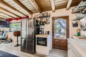 Microwave, pots/pans/lids, coffee bar, and toaster.