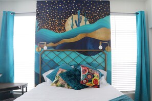 Primary Bedroom with Queen Bed, corner desk, and dresser w/smart TV