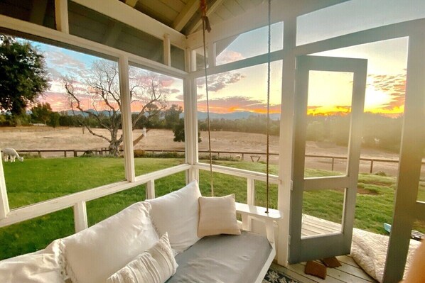 Screened-in porch off master bedroom with two cozy swinging beds.