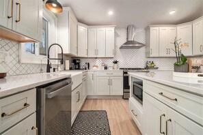 The kitchen feautures quartz counters, tile backsplash, RO system, and SS appls.