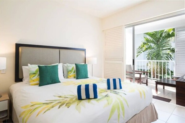 The sleeping area is set with a comfortable king bed and opens directly to the covered balcony