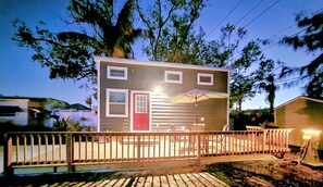 The front of Tiny Treasures with patio set and charcoal grill on the deck