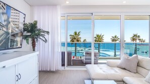 Cozy living room area with its wall mounted large TV, comfortable sofa and views.