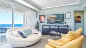 Unique oval sofa and striking yellow chairs are elegant and comfortable addition.