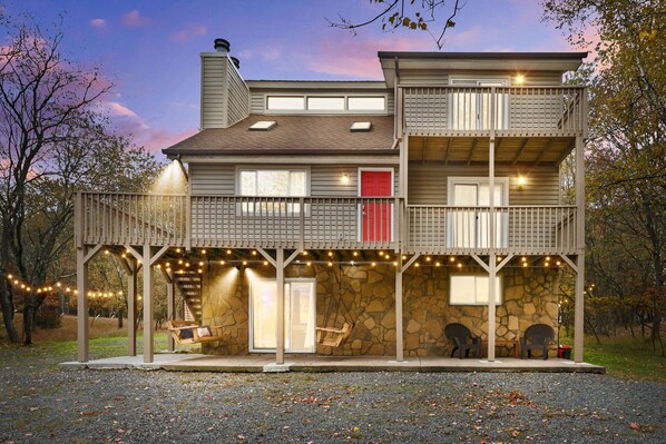 Cozy Porch Swings,Ambient Lighting,Spacious Parking Amidst Nature's Tranquility.