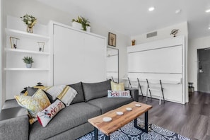 The studio features charming decor, ample storage space, and room for up to 4 to stay comfortably with twin bunk beds and a queen-pull-out bed in the living room.