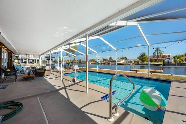 Fantastic waterfront heated pool with comfortable seating for up to 12, TV, Tiki Bar, Dolphin Fountain, and Pool Bath