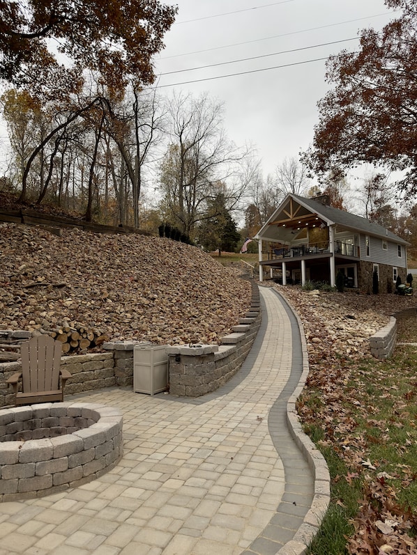 Walkway from the dock to the house with fire pit adjacent to the dock.