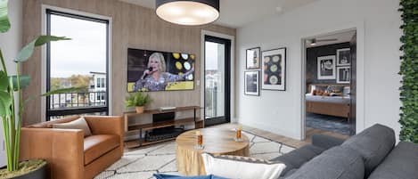 Bright living room with comfortable seating, smart TV, designer decor, and access to the private patio.