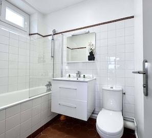 A bathroom well equipped with bath-shower, toilets and brand new sink