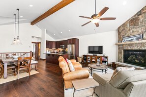 Living area with vaulted ceilings, gas fireplace, and flatscreen TV.