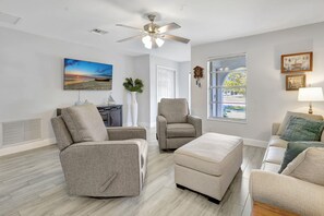 The living room features 2 reclining swivel chairs and a sleeper sofa