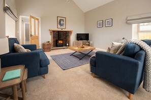 The Rushes - spacious sitting room with cosy wood burner