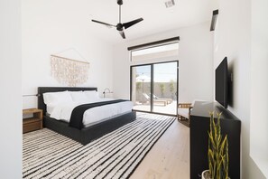 Primary Bedroom with King Bed, TV, Backyard Access, and Bathroom
