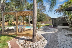 Covered outdoor dining area and pool.