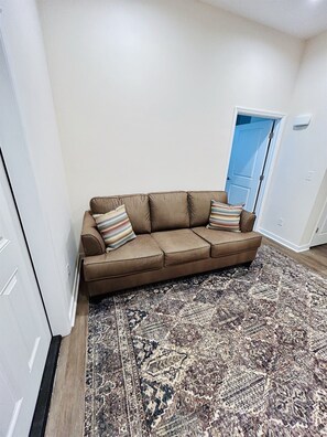 A couch with a pull-out sleeper in the foyer