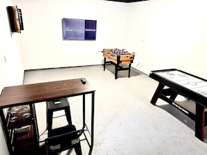 Game Room with Foosball, Air Hockey, Dot Board, Smart TV and seating area with wine glass and plates provided