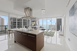 Kitchen island integrated with living room and dining area with corner views.