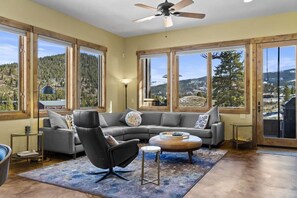 The bright living room features large windows and a wood-burning fireplace, so you can enjoy the impressive views while keeping warm by the fire.