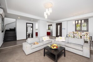 Open-plan living room with sofas, dining area, kitchen, ornamental fireplace, A/C, WiFi internet, satellite TV, and sea views