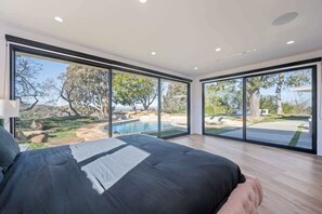 Wake up to breathtaking views in this serene bedroom with floor-to-ceiling windows overlooking a lush landscape and private pool. Natural light fills the room, creating a relaxing, airy retreat where you can unwind and reconnect with nature. :)