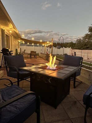 Enjoy the warming ambiance of our fire pit and cafe lights on our spacious patio