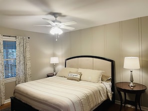 Main floor bedroom with king bed and television