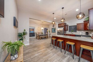 Spacious kitchen with stainless steel appliances, dining area, and living room