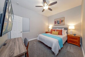 Bedroom 3 with queen-size bed, smart TV, and dedicated workspace