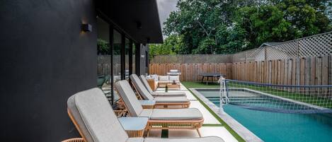 A backyard pool with brand new sun beds, perfect for soaking up the Miami sun.